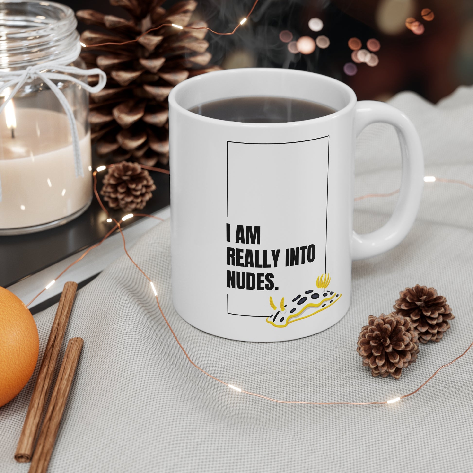White mug with humorous nudibranch text design on a table with decorative items