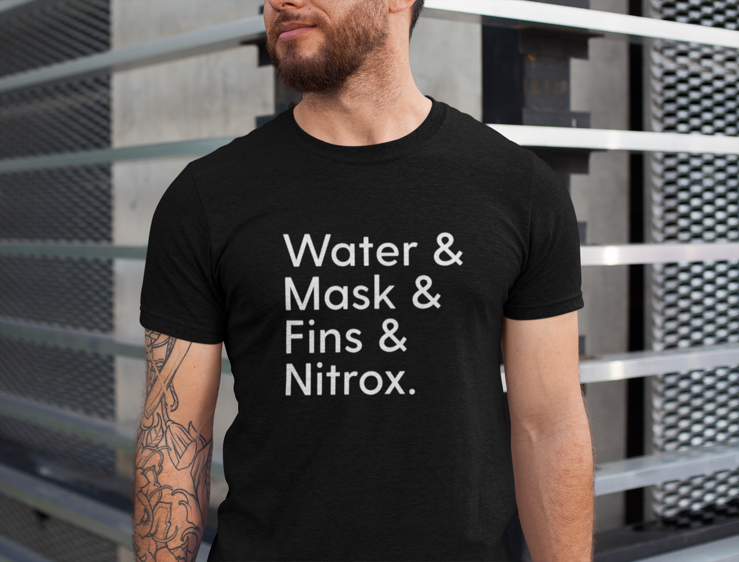 Man wearing a black scuba diving t-shirt with text 'Water & Mask & Fins & Nitrox.' standing against a metallic background.